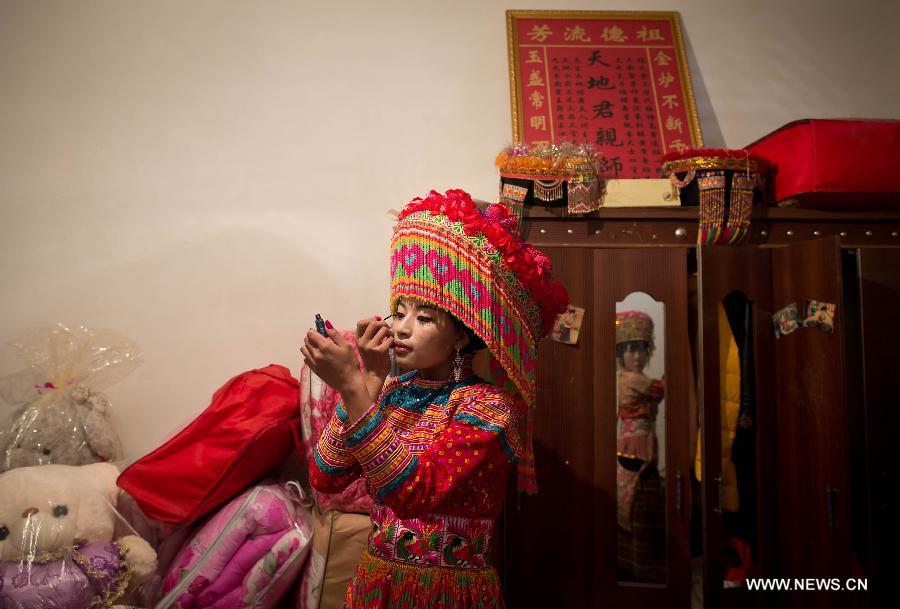 Zhang Lu, una novia de la etnia Lisu, se maquilla antes de que de comienzo la ceremonia de su boda en Xinyu, condado de Dechang, provincia de Sichuan, el 15 de febrero de 2013. (Xinhua/Jiang Hongjing)