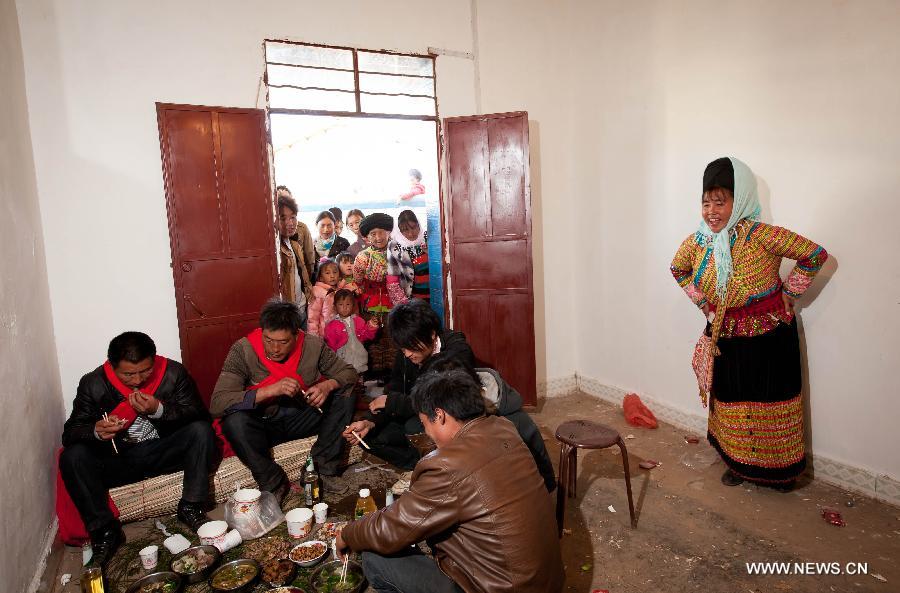 Organizadores y testigos de una boda Lisu almuerzan en la casa de la novia en Xinyu, condado de Dechang, provincia de Sichuan, el 15 de febrero de 2013. (Xinhua/Jiang Hongjing)