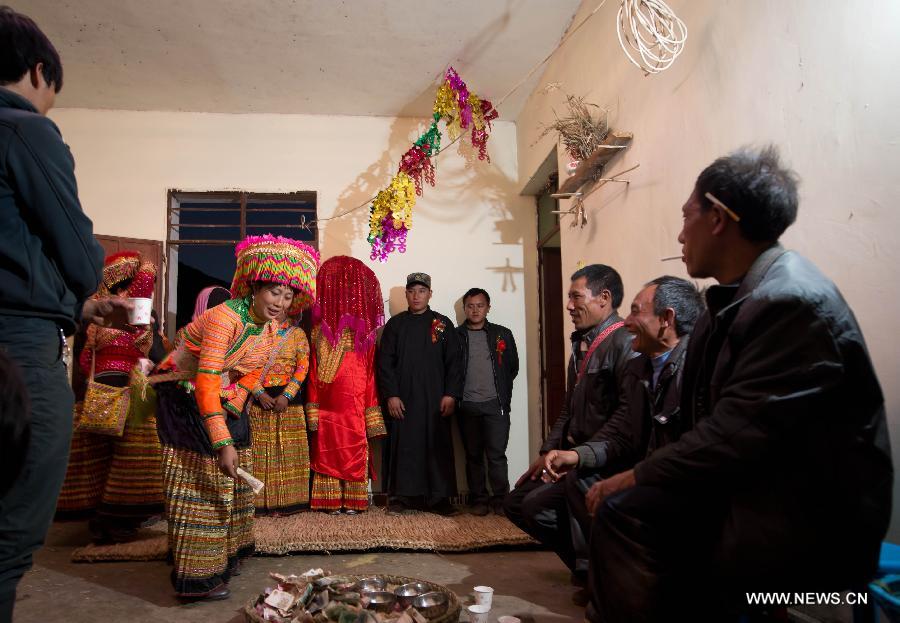 Familiares de los novios de la etnia Lisu asisten a la tradicional ceremonia que oficialmente une a la pareja como marido y mujer, en Xinyu, condado de Dechang, provincia de Sichuan, el 15 de febrero de 2013. (Xinhua/Jiang Hongjing)