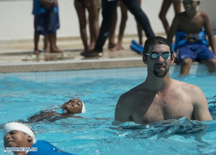 Natación: Michael Phelps visita favela de Río y da clases de natación