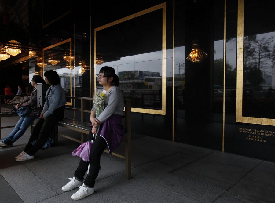 Una fan del cantante y actor de Hong Kong Leslie Cheung, lleva flores a la entrada del Hotel Mandarin Oriental de Hong Kong, el 31 de marzo de 2013, en la víspera del décimo aniversario de su muerte. [Foto/agencias]