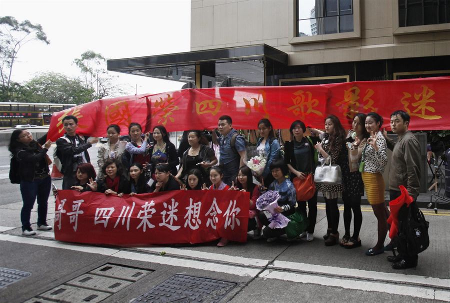 Fans del cantante y actor de Hong Kong Leslie Cheung llegados desde Sichuan posan junto a una pancarta en la entrada del Hotel Mandarin Oriental de Hong Kong, el 31 de marzo de 2013, en la víspera del décimo aniversario de su muerte. [Foto/agencias]