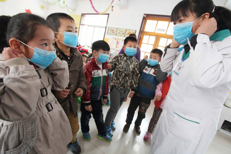 Trabajadora de la salud muestra a los estudiantes cómo usar las mascarillas para prevenir la gripe aviar en la ciudad de Weifang, provincia de Shandong, en el este de China, el 8 de abril del 2013. (Foto: Zhang Chi, Asianewsphoto)