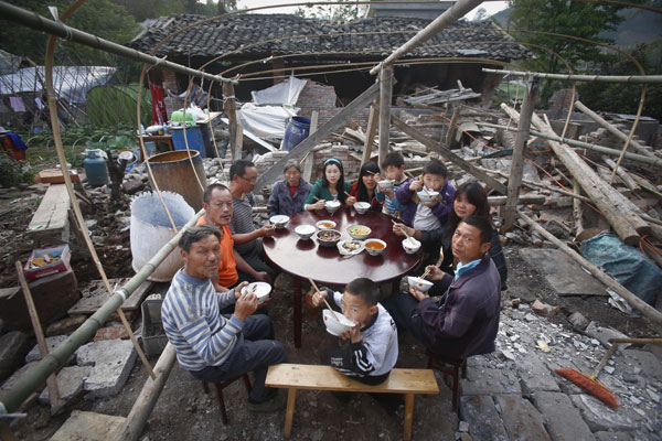 Lushan, 25/04/2013(El Pueblo en Línea)-Una familia cena junto a su casa en ruinas en el pueblo de Wuxing, condado de Lushan, provincia de Sichuan, en el suroeste de China, el 22 de abril del 2013. Un terremoto de 7,0 grados de magnitud sacudió la provincia el 20 de abril, dejando un saldo de 193 muertos y 25 desaparecidos. (Foto: Chen Zhuo, Asianewsphoto)