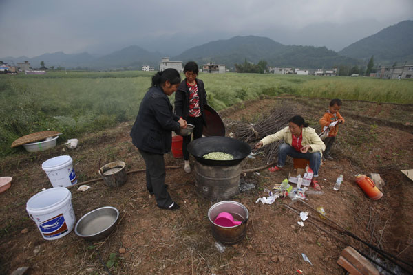 Una familia prepara la cena al aire libre en el pueblo de Shibaxi, condado de Lushan, el 22 de abril del 2013. (Foto: Chen Zhuo, Asianewsphoto)