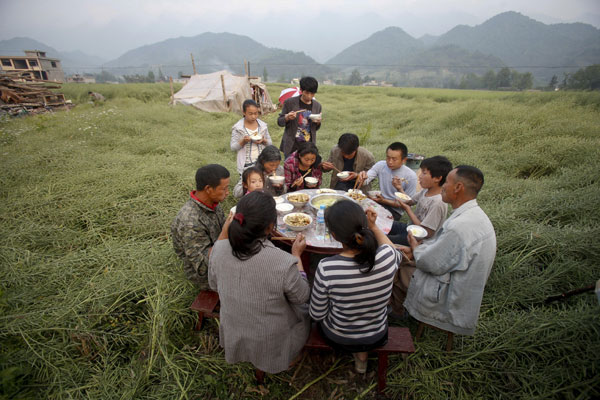 Una familia tiene una cena en un campo en el pueblo de Wuxing, condado de Lushan, el 22 de abril del 2013. (Foto: Chen Zhuo, Asianewsphoto)