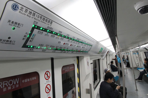 Pekín, 06/05/2013(El Pueblo en Línea)-Pasajeros a bordo de un vagón de la línea 10 del metro de Pekín, el 5 de mayo de 2013. Las tres últimas estaciones que quedaban por abrir para completar el círculo fueron inauguradas este domingo. A partir de ahora la capital cuenta con dos líneas de metro circulares, las líneas 2 y 10. Con 45 estaciones, la línea 10 se extiende por 57km que se pueden recorrer en 104 minutos. [Foto/Xinhua] 