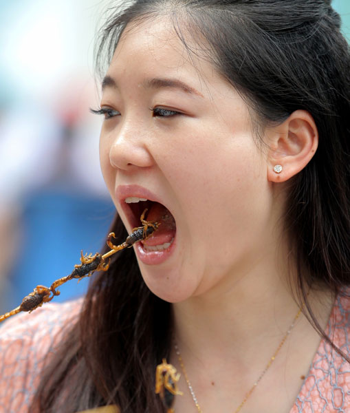 Duan Ying, de 24 años, enseña un escorpión frito en Wangfujing, Pekín. Wang Jing / China Daily