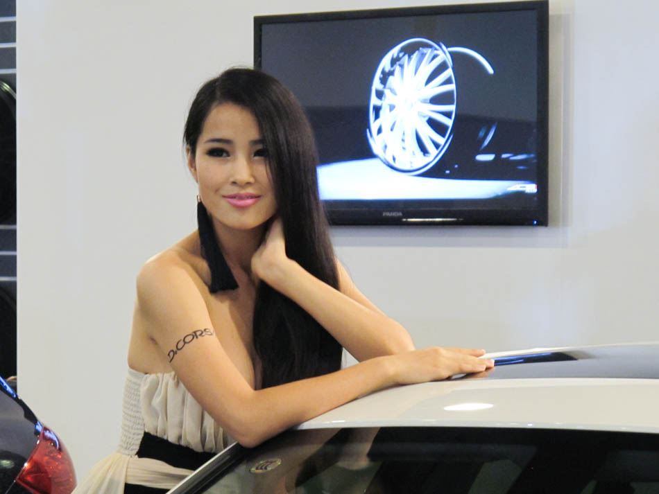 Una modelo posa junto a un Porsche modificado en el Salón de  "Todo sobre coches modificados y Todo sobre  al caravanas" de China 2013, el 15 de junio de 2013, en el Centro Nacional de Convenciones de China en Pekín. [Hao Yan / chinadaily.com.cn]