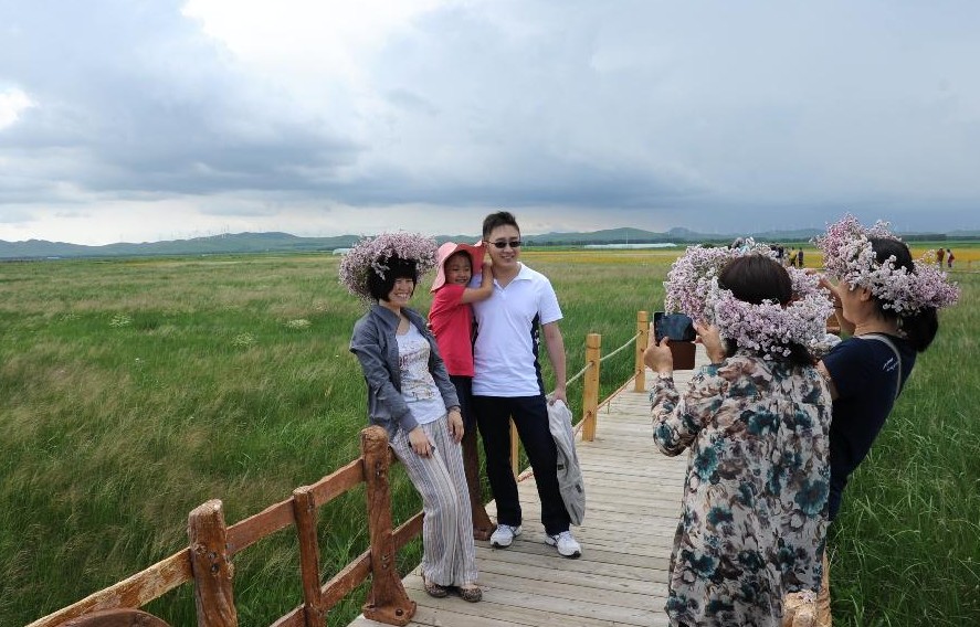 Turistas posan para fotos en un lugar pintoresco en la pradera Bashang e en el distrito de Guyuan, provincia de Hebei, norte de China, el 20 de julio de 2013. La pradera ha atraído a muchos turistas para disfrutar del clima fresco. (Xinhua / Wang Xiao)