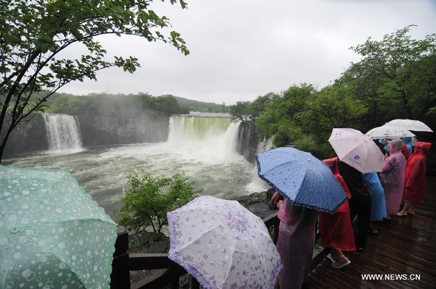 Turistas disfrutan del paisaje de la cascada Diaoshuilou en el lago Jingpo en la ciudad de Mudanjiang, provincia de Heilongjiang, noreste de China, el 21 de julio de 2013. El nivel del agua del lago Jingpo aumentó significativamente debido a las continuas lluvias. (Xinhua / Zhang Chunxiang) 