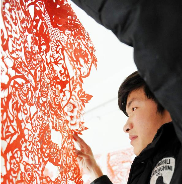 Chang espera haya más jóvenes que quieran aprender este arte. Es la razón por la que ahora enseña el arte de cortar papel en varias escuelas primarias locales. [Foto/Xinhua]