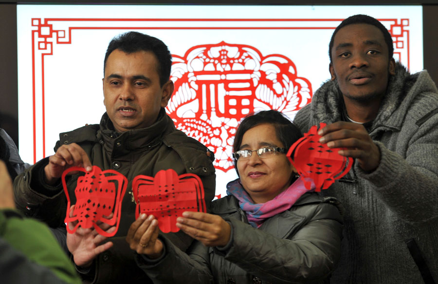 Estudiantes internacionales muestran sus piezas de papel cortado en Nanjing, provincia de Jiangsu, el 20 de enero de 2014. [Foto / Asianewsphoto]
