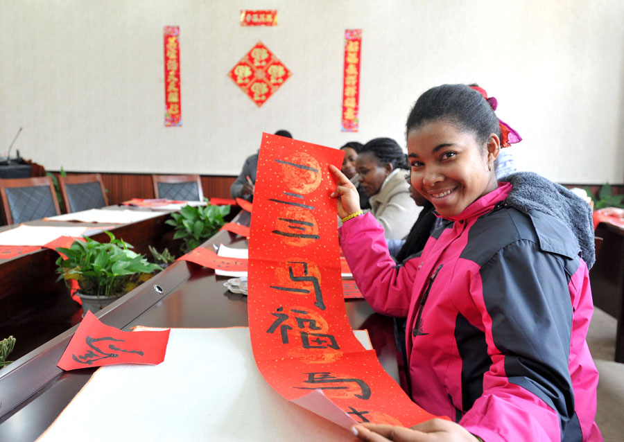 Una estudiante internacional muestra su poema típico de Año Nuevo Chino en Nanjing, provincia de Jiangsu, el 20 de enero de 2014. [Foto / Asianewsphoto]