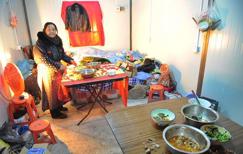 Una mujer prepara la comida dentro de uno de los contenedores usados como viviendas en Taiyuan, provincia de Shanxi, el 19 de febrero de 2014.