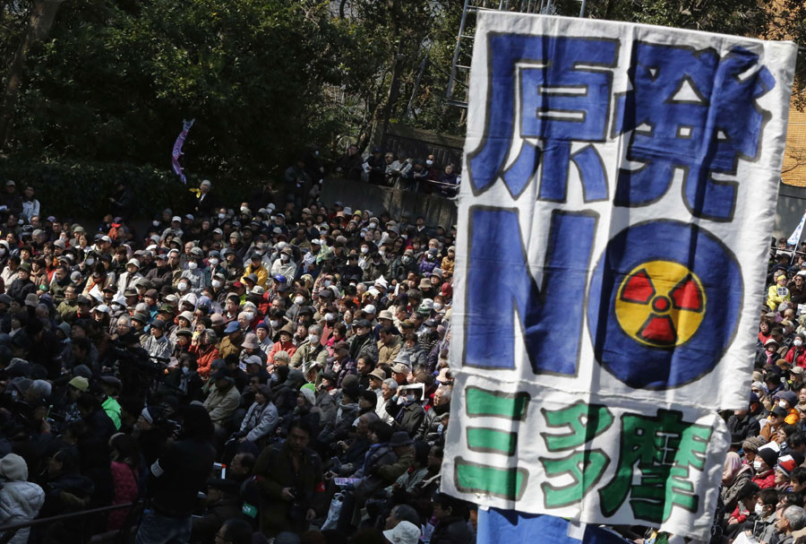 Los manifestantes antinucleares detrás de una pancarta que pone "No Nukes" durante la marcha en Tokio, el 9 de marzo de 2014. [Foto/agencias]