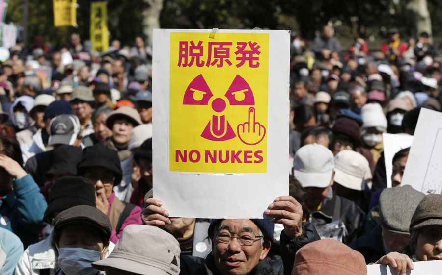 Un manifestante antinuclear sostiene un cartel que pone "No Nukes" durante la marcha de manifestantes en Tokio, el 9 de marzo de 2014. [Foto/agencias]