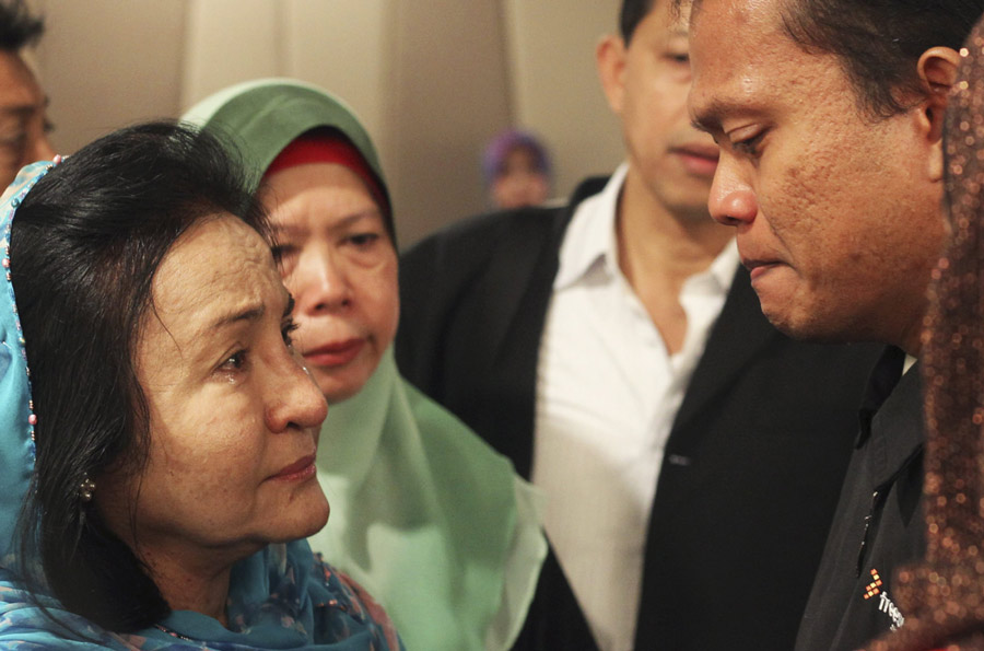 Rosmah Mansor (izquierda), esposa del primer ministro de Malasia Najib Razak, llora con los familiares de los pasajeros desaparecidos en el vuelo de Malaysia Airlines MH370, en un hotel de Putrajaya, Malasia, el 9 de marzo de 2014. [Foto/agencias]