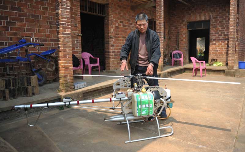 Zhang Aiguo junto a su dron casero en Changsha, provincia de Hunan, el 20 de marzo de 2014. Zhang ha construido cinco aviones teledirigidos y planea construir otros diez antes de finales de año. Cada avión le cuesta unos 120.000 yuanes (19.000 dólares). [Foto/Xinhua]