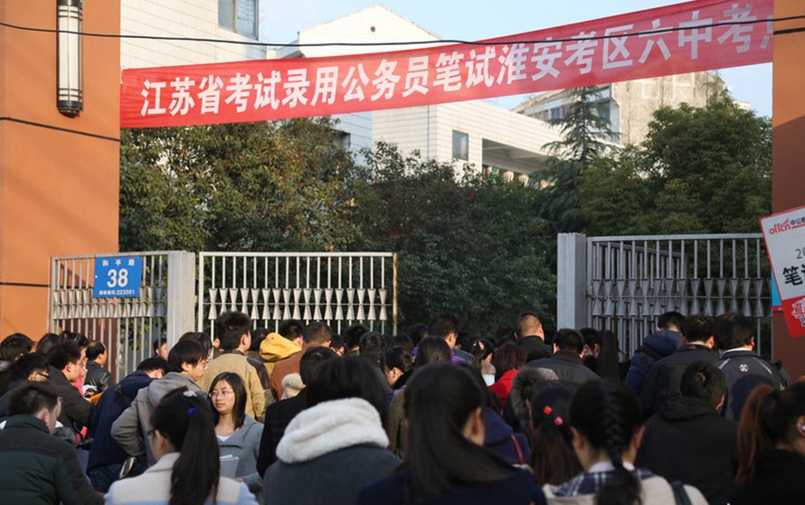 Los aspirantes a puestos de funcionario en la provincia de Jiangsu esperen fuera del lugar de la prueba en el Sexto Instituto de la ciudad de Huai'an, el 23 de marzo de 2014. Más de 240.000 solicitantes se presentaron al examen de provincial de funcionarios en 14 lugares de toda la provincia.