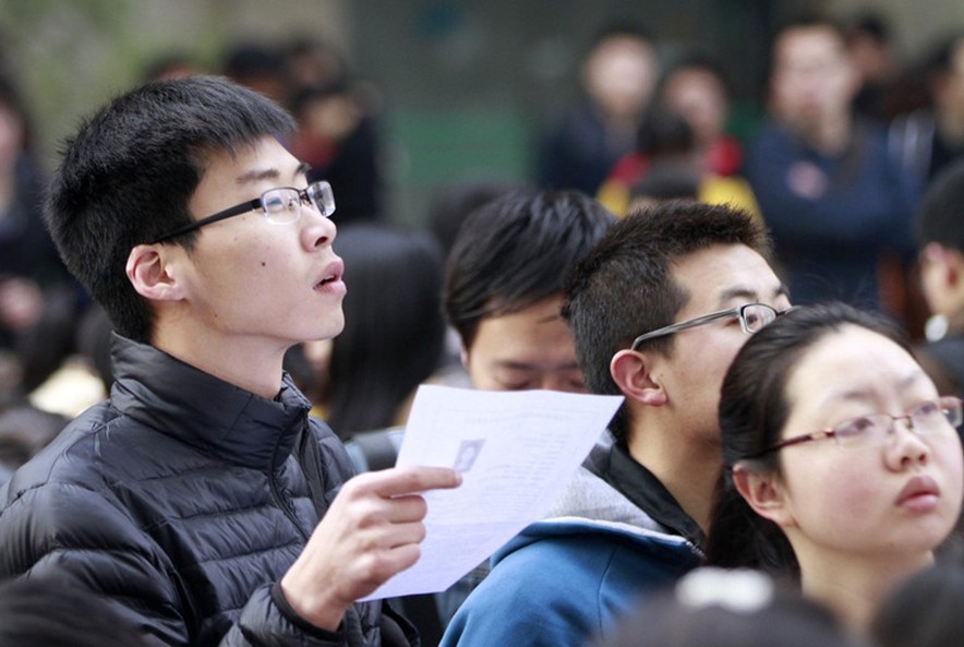 Los aspirantes a puestos de funcionario en la provincia de Jiangsu esperan fuera del lugar del examen en la Universidad de Ciencias Forestales de Nanjing, el 23 de marzo de 2014. 