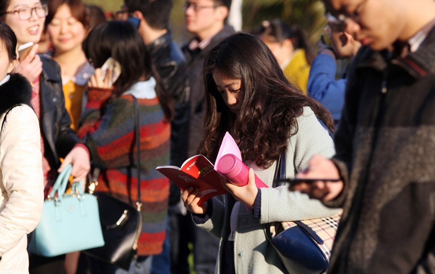 Los solicitantes estudian para el examen de funcionario en la provincia de Jiangsu fuera del lugar de la prueba en la Universidad de Changzhou, el 23 de marzo de 2014. 