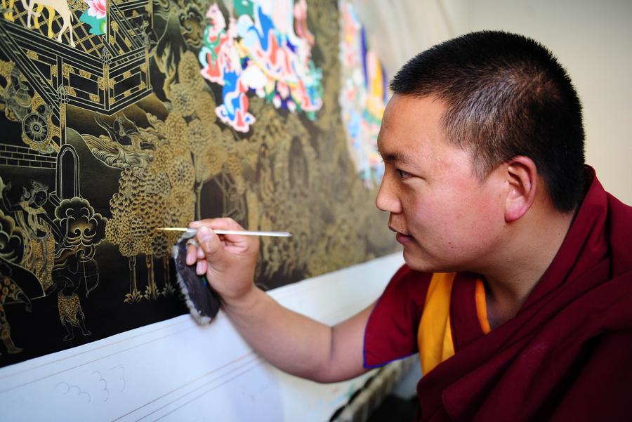 Gazang Jiacuo, un monje tibetano y pintor de Thangka, pinta una obra de Thangka. Foto del 18 de marzo de 2014. [Foto / Xinhua]