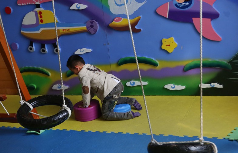 Un niño juega solo en un aula de un centro de rehabilitación de Kunming, el 1 de abril, en vísperas del Día Mundial de Concienciación sobre el Autismo, el 2 de abril. Los "niños de las estrellas", como se conoce a las personas autistas en China, tiene un desarrollo del lenguaje lento, con dificultades en la comunicación y falta de atención.