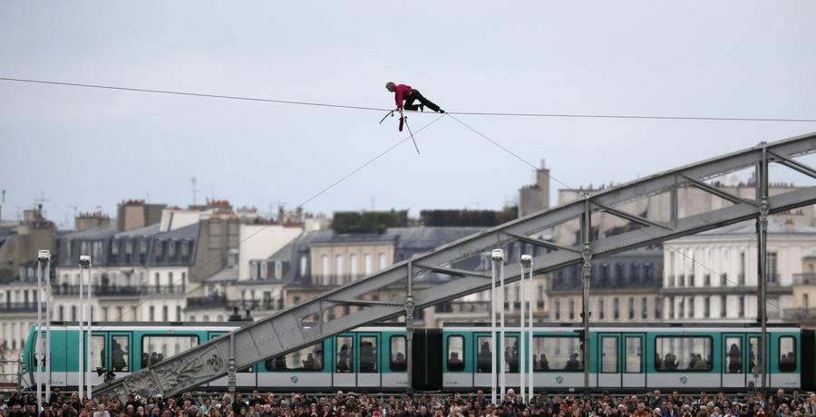 El acróbata francés Denis Josselin hace equilibrio en la cuerda al cruzar el río Sena frente al puente de Austerlitz en París, el 6 de abril de 2014. [Foto/agencias]