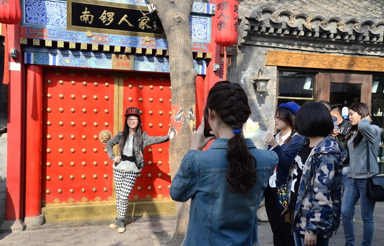 Foto del 1 de abril de 2014 muestra la renovada calle Nanluoguxiang en Pekín, un lugar turístico muy conocido que atrajo a una multitud de turistas chinos y extranjeros. Los visitantes vienen a ver el "viejo" Pekín a los hutones, que se encuentran en los alrededores del lago Houhai y Nanluoguxiang.