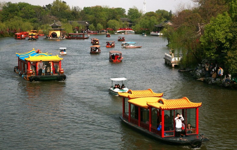 Foto del 7 de abril de 2014. Los visitantes hacen viajes en barco por el Lago del Oeste Delgado de Yangzhou.