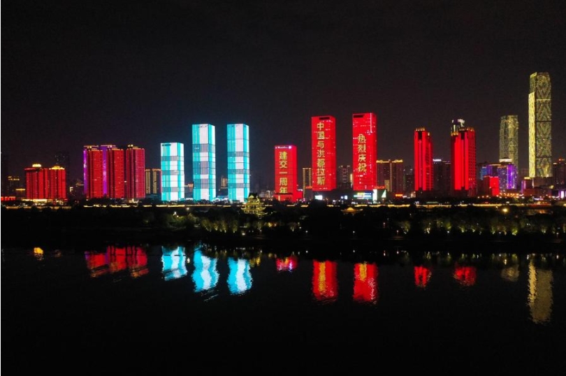 Vista panorámica de una hilera de edificios a lo largo del río Xiangjiang iluminados para celebrar el primer aniversario del establecimiento de relaciones diplomáticas entre China y Honduras, en Changsha, capital de la provincia central china de Hunan, el 26 de marzo de 2024. (Xinhua/Xue Yuge)