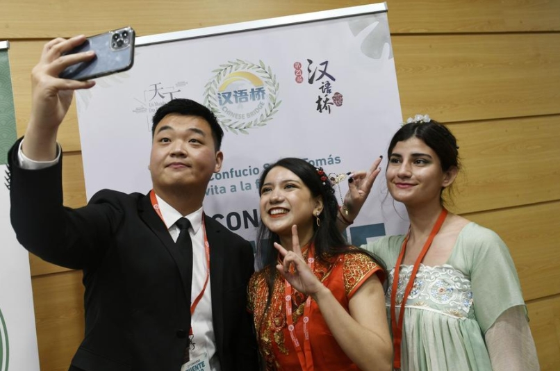 Imagen del 9 de junio de 2022 de concursantes posando para una fotografía con un trabajador al término del 21 Concurso de Dominio del Idioma Chino "Puente Chino" para estudiantes universitarios chilenos en la Universidad Santo Tomás, en Viña del Mar, Chile. (Xinhua/Universidad Santo Tomás)