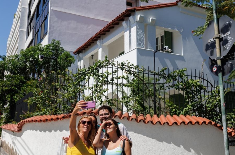 Personas se toman una fotografía frente a la casa utilizada como lugar de rodaje de la película brasileña "Aún Estoy Aquí", en el barrio de Urca, en Río de Janeiro, Brasil, el 5 de marzo de 2025. (Xinhua/Claudia Martini)