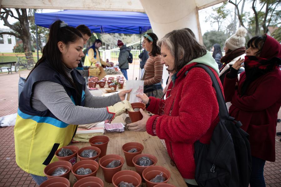 Una voluntaria de la comuna 14 asesora y entrega una bolsa con esquejes de rosal a una mujer en el Rosedal del Parque Tres de Febrero, en la ciudad de Buenos Aires, capital de Argentina, el 10 de julio de 2025. (Xinhua/Martín Zabala)