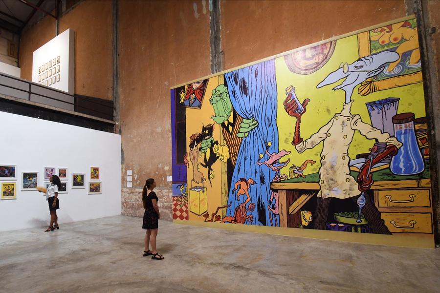 Mujeres observan pinturas realizadas por el cineasta y pintor cubano, Juan Padrón, exhibidas en una galería en el marco de la celebración del 65º aniversario del establecimiento de relaciones diplomáticas entre China y Cuba, en el Barrio Chino de la Habana, en La Habana, capital de Cuba, el 24 de septiembre de 2025. (Xinhua/Joaquín Hernández)