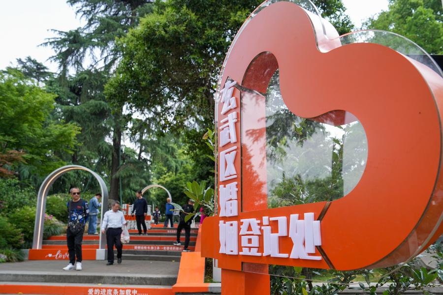 Personas pasan frente a una oficina de registro matrimonial en el Parque del Lago Xuanwu, en Nanjing, capital de la provincia oriental china de Jiangsu, el 10 de mayo de 2025. (Xinhua/Li Bo)
