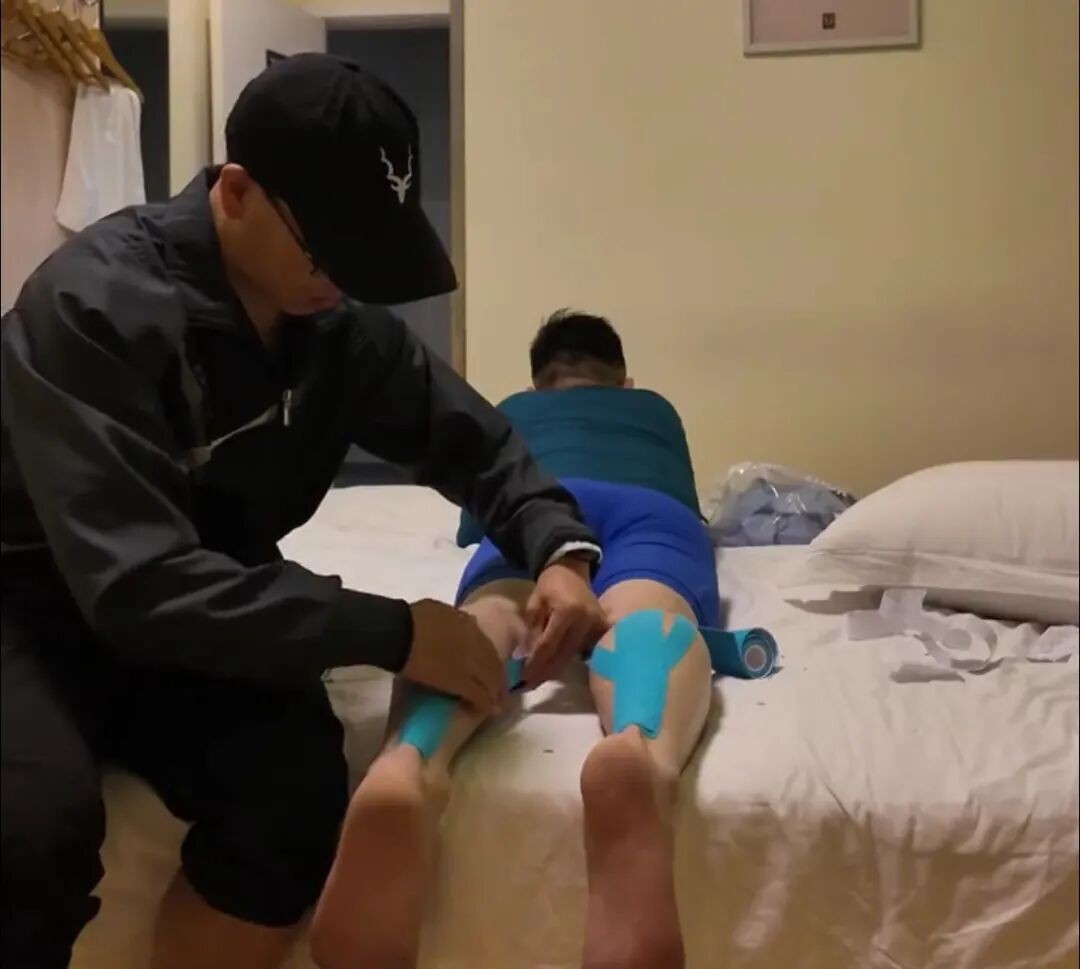 Un compañero de carrera ayuda a un participante antes de iniciar el maratón. (Foto: Qianjiang Evening News)