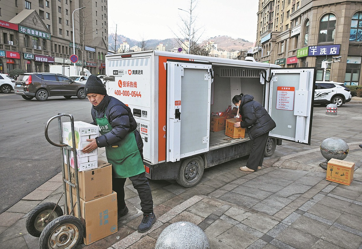 Residentes recogen paquetes de un vehículo de entrega no tripulado en Chengyang , Qingdao, provincia de Shandong, 28 de enero del 2026. (Foto: Li Ziheng/ Xinhua)