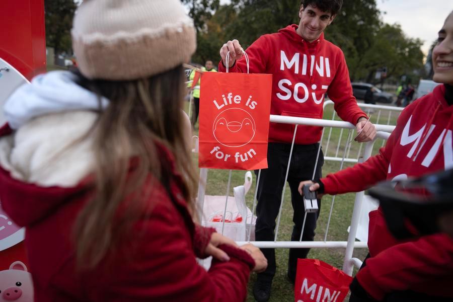 Imagen del 22 de mayo de 2026 de un empleado de la cadena Miniso entregando un premio a una mujer durante un evento organizado por la cadena internacional de tiendas minoristas de origen chino Miniso frente al Planetario de Buenos Aires, en la ciudad de Buenos Aires, capital de Argentina. (Xinhua/Martín Zabala) 