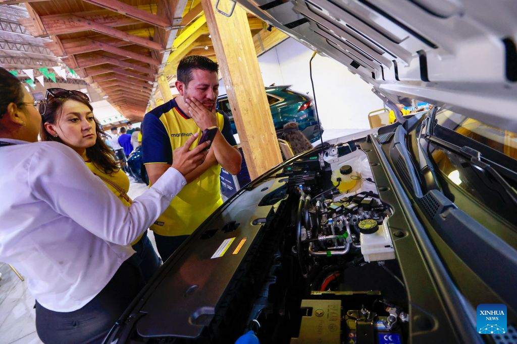 Imagen del 20 de junio de 2026 de expositores explicando las características mecánicas de un vehículo eléctrico a visitantes durante la Expo Auto Quito 2026 realizada en el Centro de Exposiciones Quito, en la ciudad de Quito, capital de Ecuador. Los vehículos eléctricos e híbridos de origen chino acaparan la atención en la Expo Auto Quito 2026, Movilidad Sustentable, una feria automotriz dedicada a la electromovilidad que abrió sus puertas el sábado para exhibir las más recientes tendencias e innovaciones del mercado. (Xinhua/Ricardo Landeta)