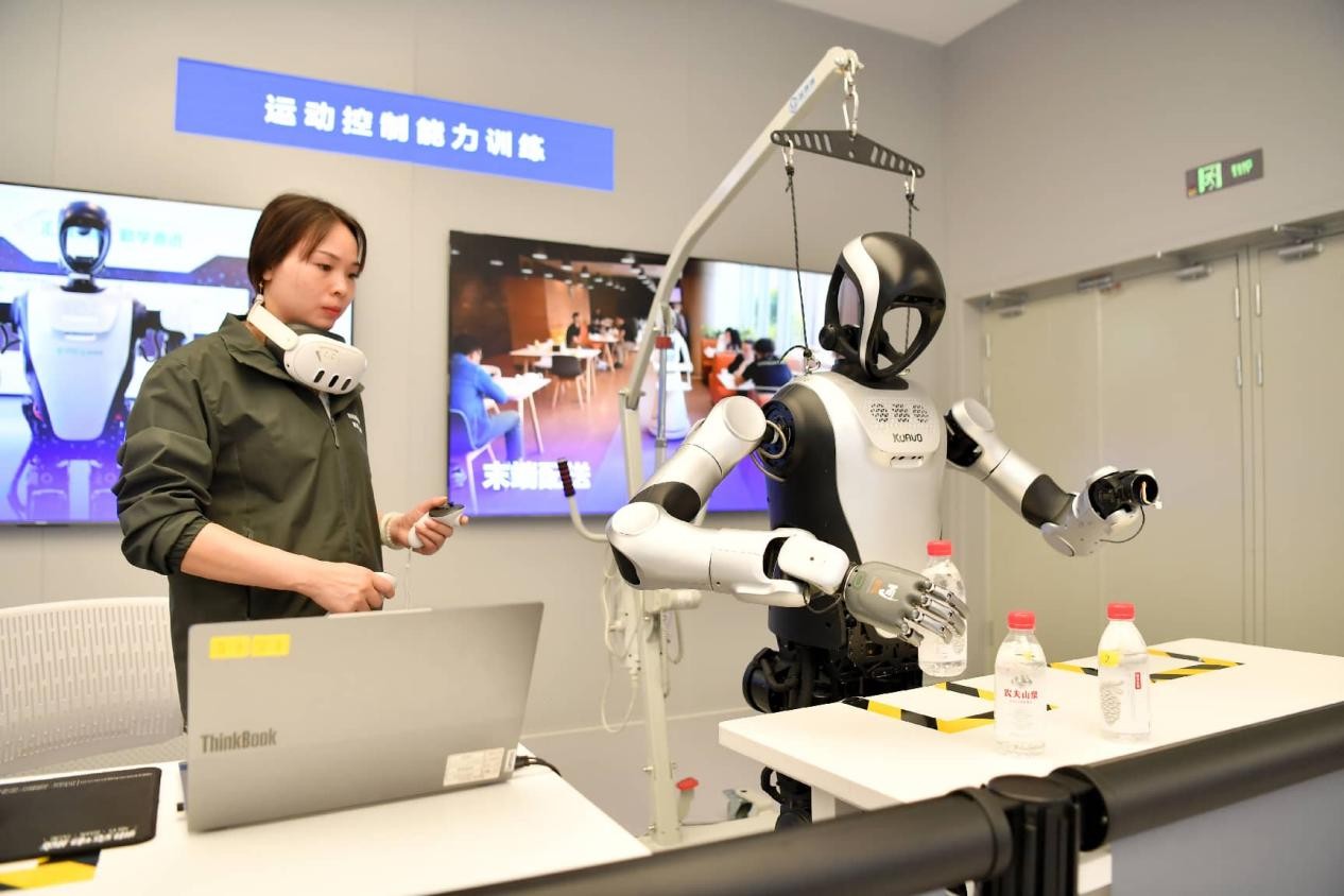 Una instructora realiza un entrenamiento de control de movimiento para un robot en una base de entrenamiento de robots con inteligencia incorporada en la provincia de Sichuan, en el suroeste de China. (Foto/Wang Yong)