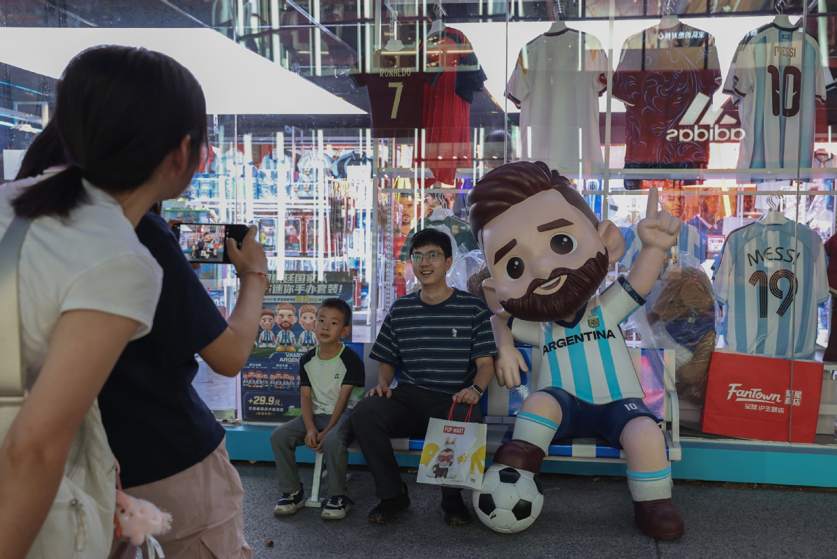 Visitantes posan junto a una estatua del futbolista argentino Lionel Messi en un centro comercial en Beijing, 12 de julio de 2026. [Foto: VCG]