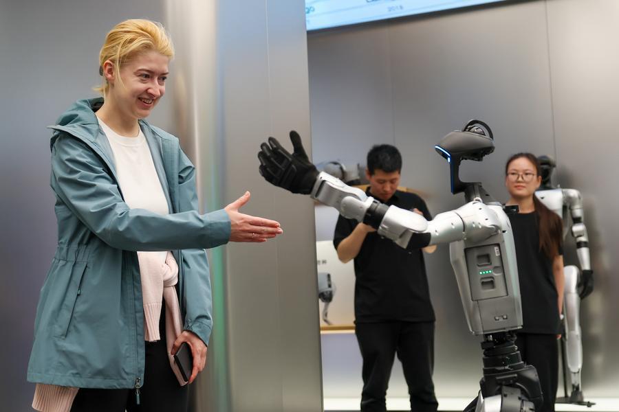 Una turista rusa interactúa con un robot en una tienda de Unitree Robotics, en Beijing, capital de China, el 30 de abril de 2026. (Xinhua/Ju Huanzong)
