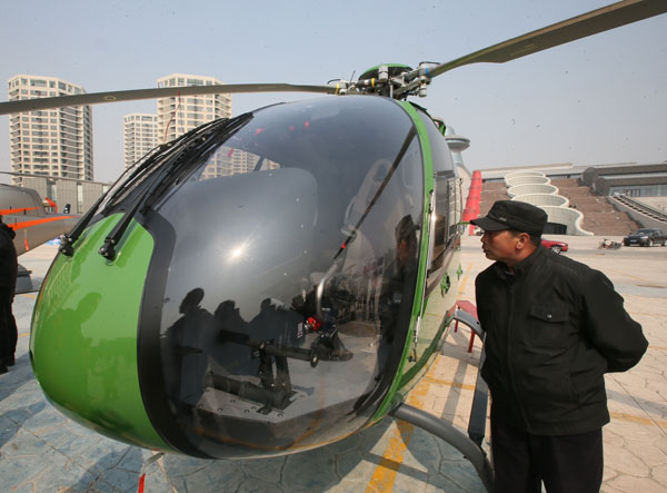 Un visitante observa un helicóptero en venta en una tienda de helicópteros privados de Pekín el sábado. (Foto: Jiang Guijia / China Daily)